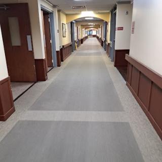 A view of a long hallway with doors on either side and a clean, well-maintained floor.