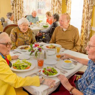 A group of elderly people enjoying a meal together at a restaurant.