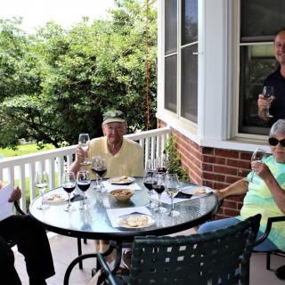 A group of people enjoying wine together on a patio.