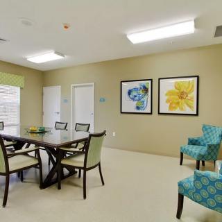 A modern meeting room with a conference table, chairs, and colorful wall art.