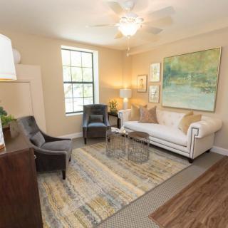 A cozy and well-decorated living room with a sofa, armchairs, and artwork on the walls.