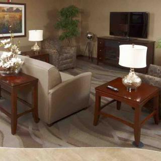 A cozy living room with a sofa, wooden tables, and elegant table lamps.