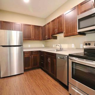 A modern kitchen with stainless steel appliances and wooden cabinets.