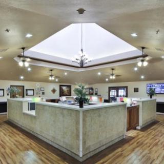 A modern office reception area featuring a central desk with ambient lighting and wood flooring.