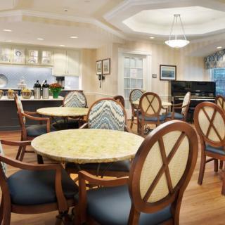 A cozy dining area with round tables and cushioned chairs, featuring a warm and inviting interior design.