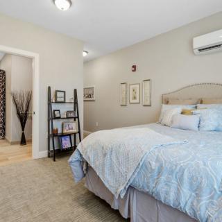 A cozy bedroom with a neatly made bed, minimal decor, and neutral color tones.