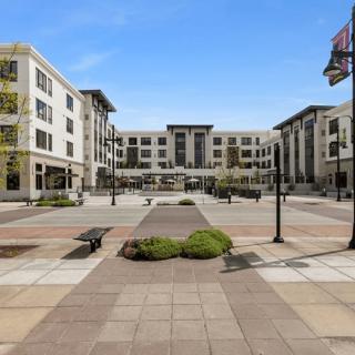 A modern residential complex with a spacious central plaza and landscaping.