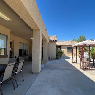 A sunny outdoor patio area featuring seating and a gazebo, perfect for relaxation.