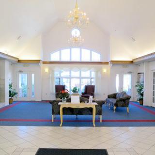 Spacious lobby with elegant furnishings and a chandelier.