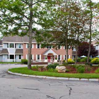 A picturesque residential building surrounded by greenery and landscaping.