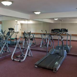 An indoor gym with exercise equipment including treadmills and stationary bikes.