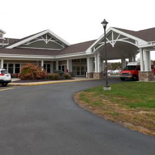 A welcoming entrance to a community building, featuring a well-maintained driveway and modern architecture.