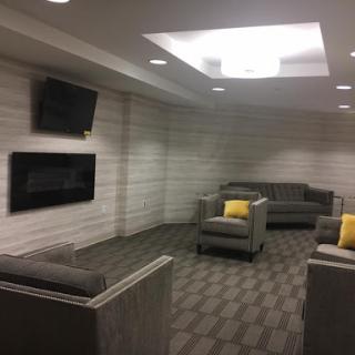 A modern lounge area featuring comfortable seating and televisions, designed for relaxation.