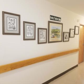 A hospital hallway adorned with a series of framed artworks.