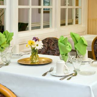A beautifully arranged dining table with a floral centerpiece and neatly folded napkins.