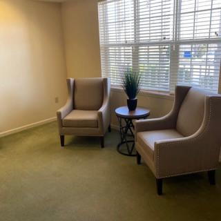 A cozy seating area with two armchairs and a small table by the window.