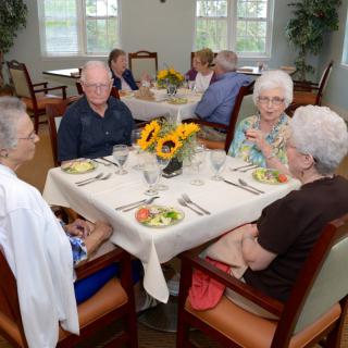 A group of seniors enjoying a meal together in a dining area.