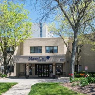 Exterior view of a building entrance surrounded by trees on a sunny day.