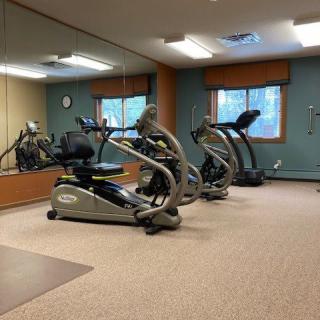 A gym room equipped with exercise machines and fitness equipment.
