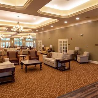 A spacious and elegantly designed lounge area with comfortable seating, warm lighting, and a decorative chandelier.