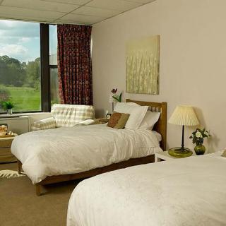 A cozy hotel room featuring two neatly made beds, a window with a scenic view, and tasteful decor.