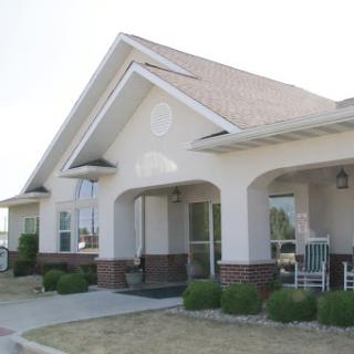 A charming single-story residential house with a welcoming front porch and well-maintained landscaping.