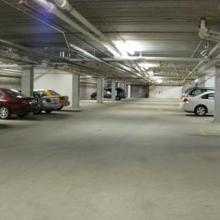 An underground parking lot with several parked cars.