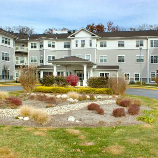 A large residential building with manicured landscaping in the foreground.
