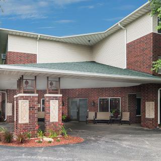 Entrance of a commercial building with a brick facade and covered driveway.