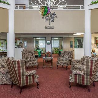 A cozy lobby area with patterned armchairs and a decorative chandelier.