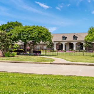 A beautiful residential property featuring well-maintained landscaping and a clear blue sky.