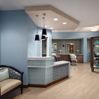 A modern reception area with blue walls and stylish pendant lighting.