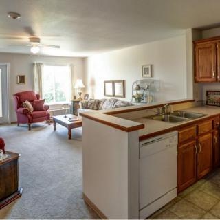 A cozy open-concept living room and kitchen area with natural light.