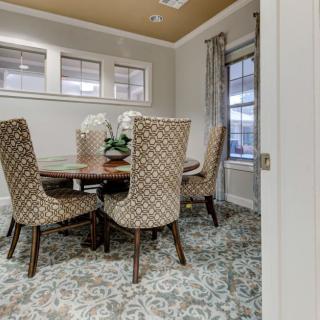 A cozy dining room with patterned chairs and a round table, featuring elegant interior design elements.