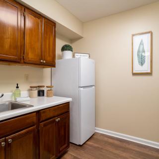 A modern kitchen featuring wooden cabinets and a white refrigerator.