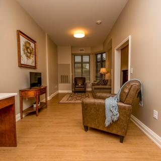 Cozy living room with armchair, television, and warm lighting.