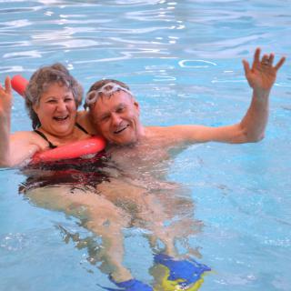 Senior couple enjoying a swim together in the pool.