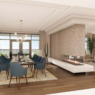 A modern dining room featuring a large table with blue chairs, a central fireplace, and expansive windows offering natural light.