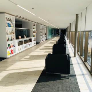 A modern library corridor with bookshelves and a seating area.