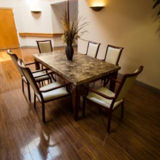 Elegant dining room with a large wooden table and upholstered chairs.
