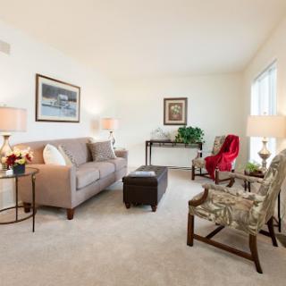 A cozy living room featuring a soft sofa, patterned armchairs, and elegant decor.