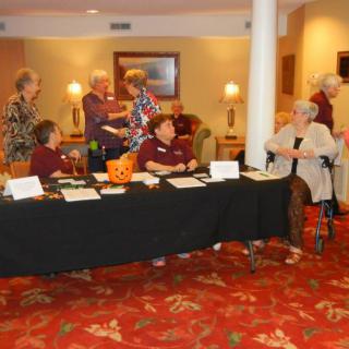 A group of people gathered around a registration table at an indoor event.