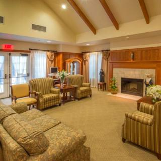 A cozy living room with sofas, armchairs, and a fireplace.