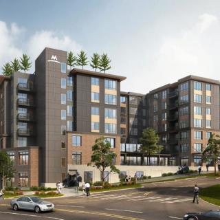 A modern apartment building with green rooftop gardens in an urban setting.