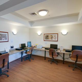 A modern office with multiple workstations equipped with computers and comfortable chairs.