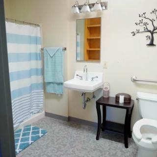 A clean, well-organized bathroom with a sink, shower, and decorative elements.