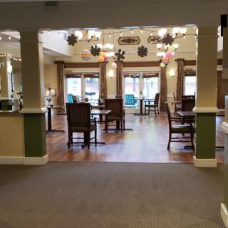 A spacious dining area with tables and chairs, decorated for an event.
