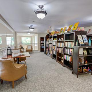 A cozy library interior with bookshelves and a reading area.