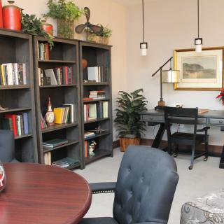 A well-organized office space with bookshelves, a desk, and comfortable seating.
