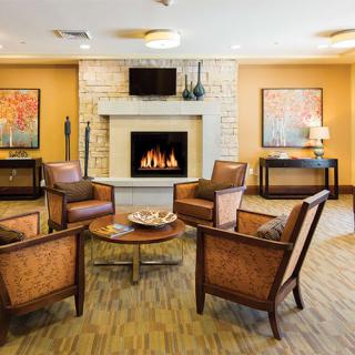A cozy living room with a central fireplace and comfortable seating.